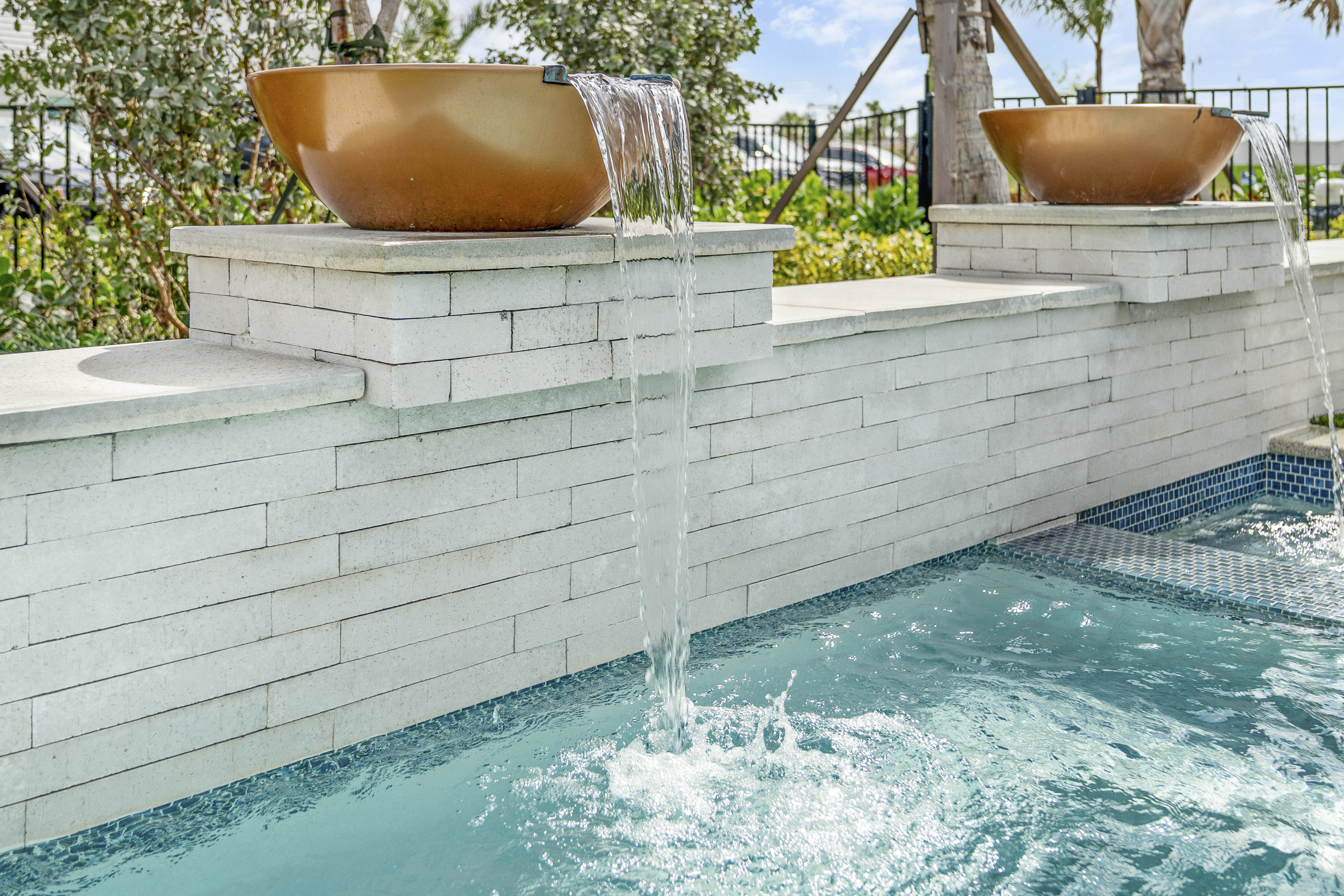 Sheer descent water feature flowing into pool, close-up detail shot