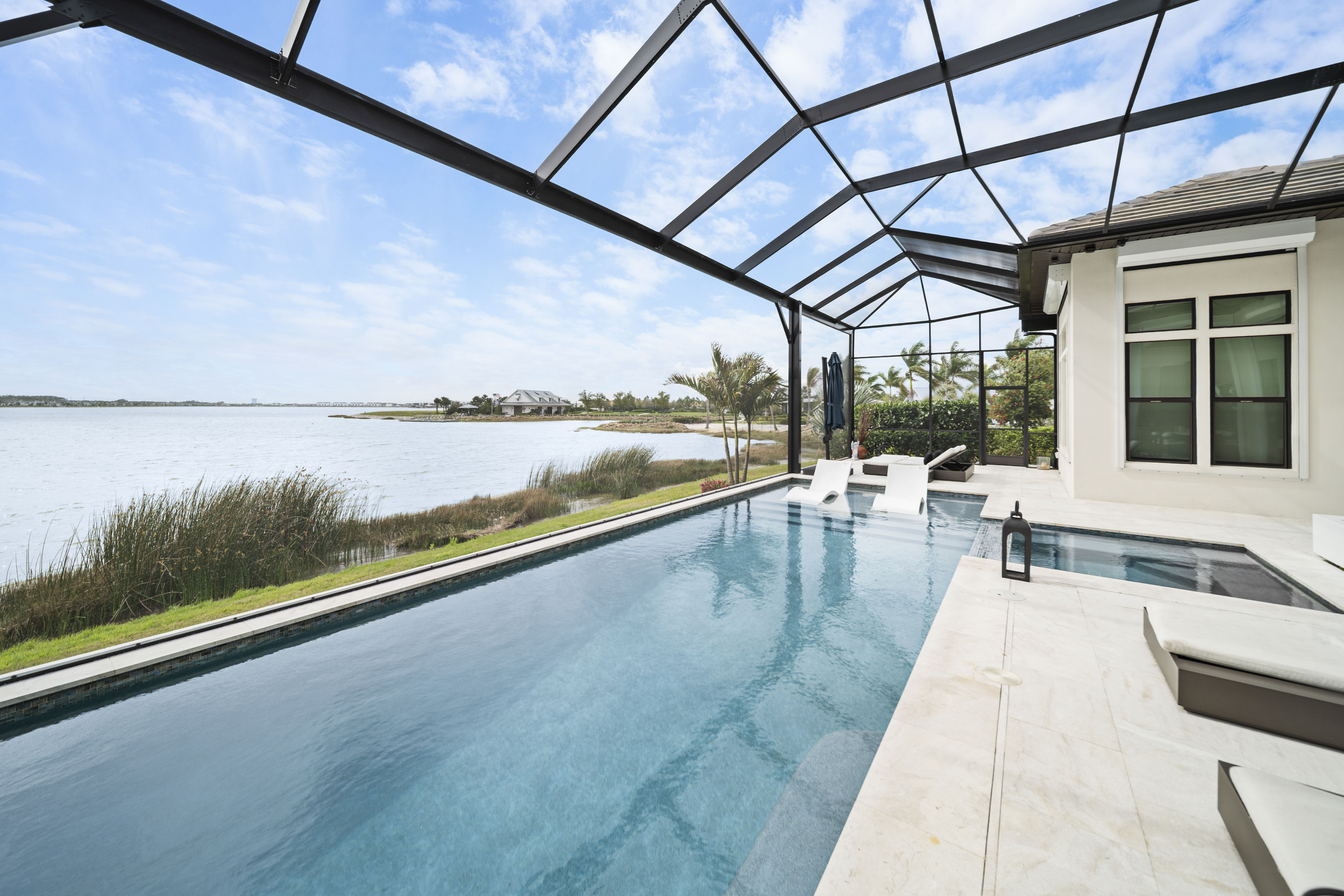 Award-winning vanishing edge pool at twilight, the waterline merging with the horizon over open water, Swim Inc. Aqua Magazine First Place design