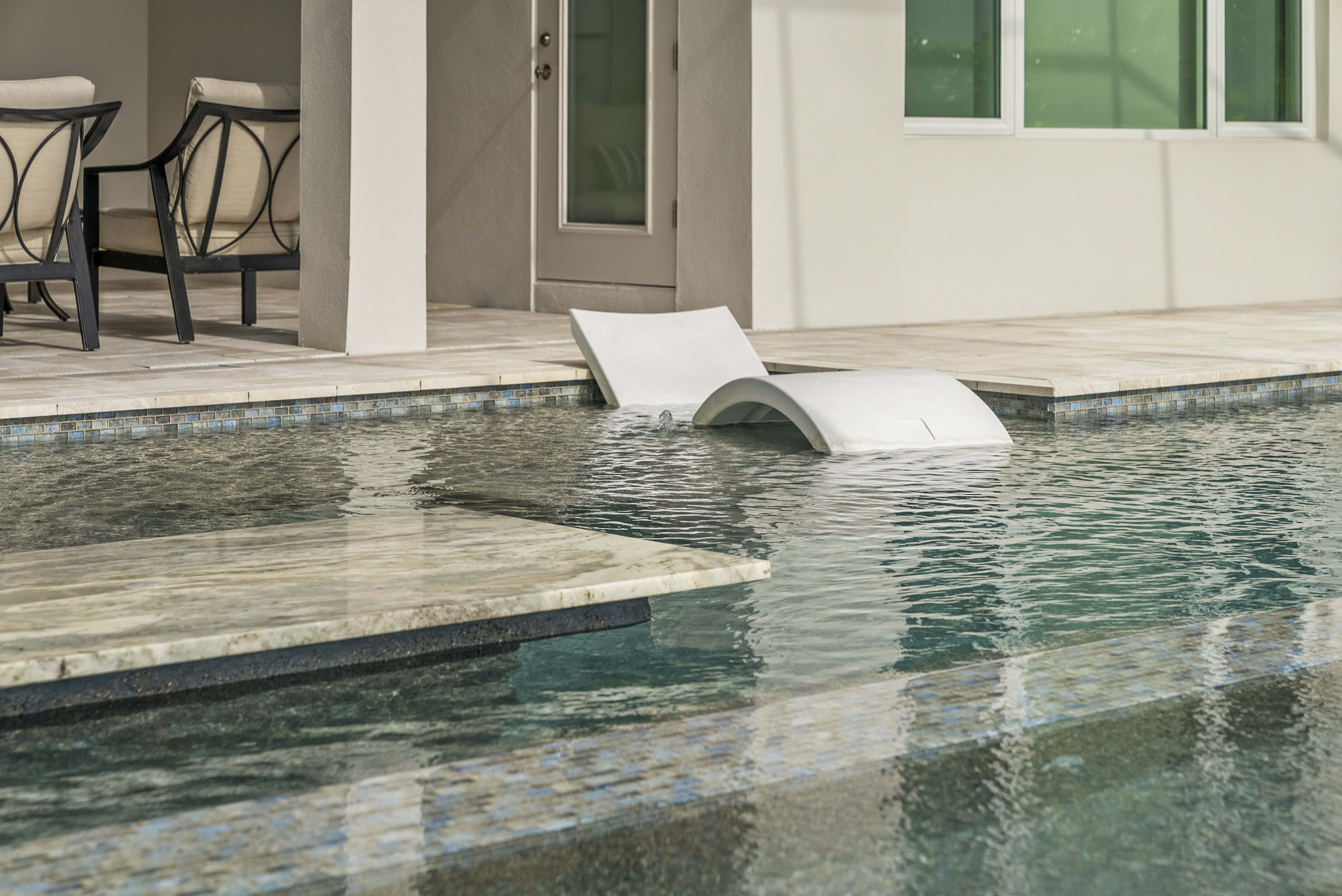 Oversized flush spa at twilight with warm color-changing LED lighting on resort-style pool, Sarasota, FL, Swim Inc.